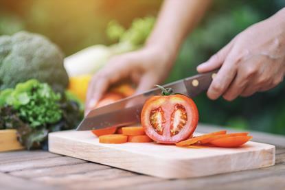 Chopping tomatoes on wooden board