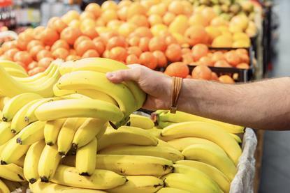 Picking up bananas in supermarket Adobe Stock